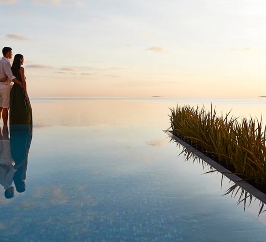 Couple watching the sunset by the pool